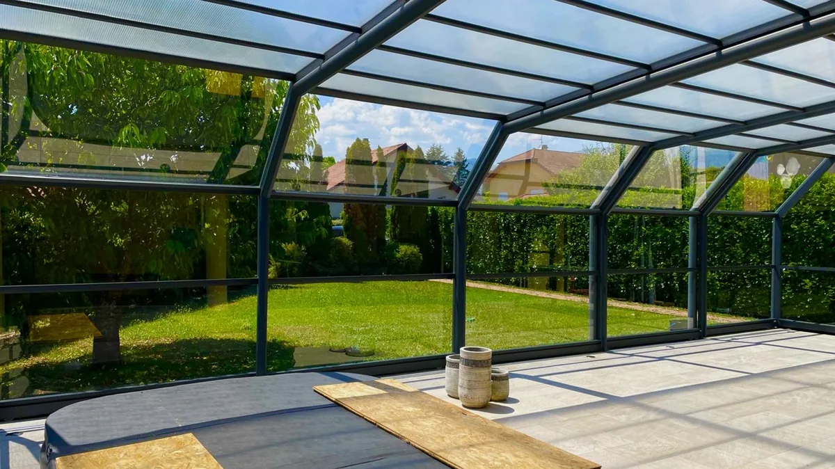 Véranda aux vitres parfaitement nettoyées par Klinn, verre net et vue dégagée sur le jardin